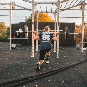 Outdoor Traing mit Langhantel Person geht in die Knie
