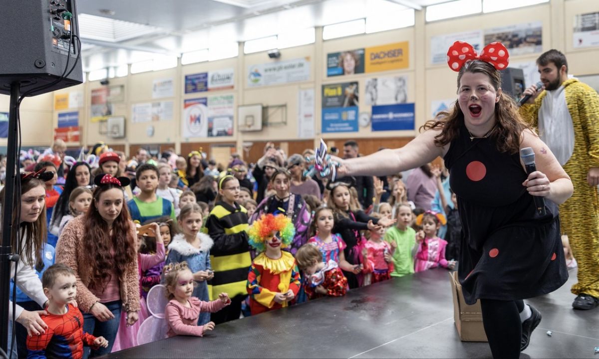 Singende verkleide Frau mit Mikrofon in der Hand